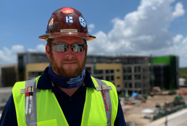 澳门足彩app's Nathan Faloon st和ing on a jobsite.